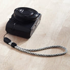Paracord Lanyard Wrist Strap [2 Pack] - Gray and white checkered paracord wrist strap attached to a black digital camera.