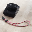Paracord Lanyard Wrist Strap [2 Pack] - Pink camouflage paracord wrist strap attached to a black digital camera.