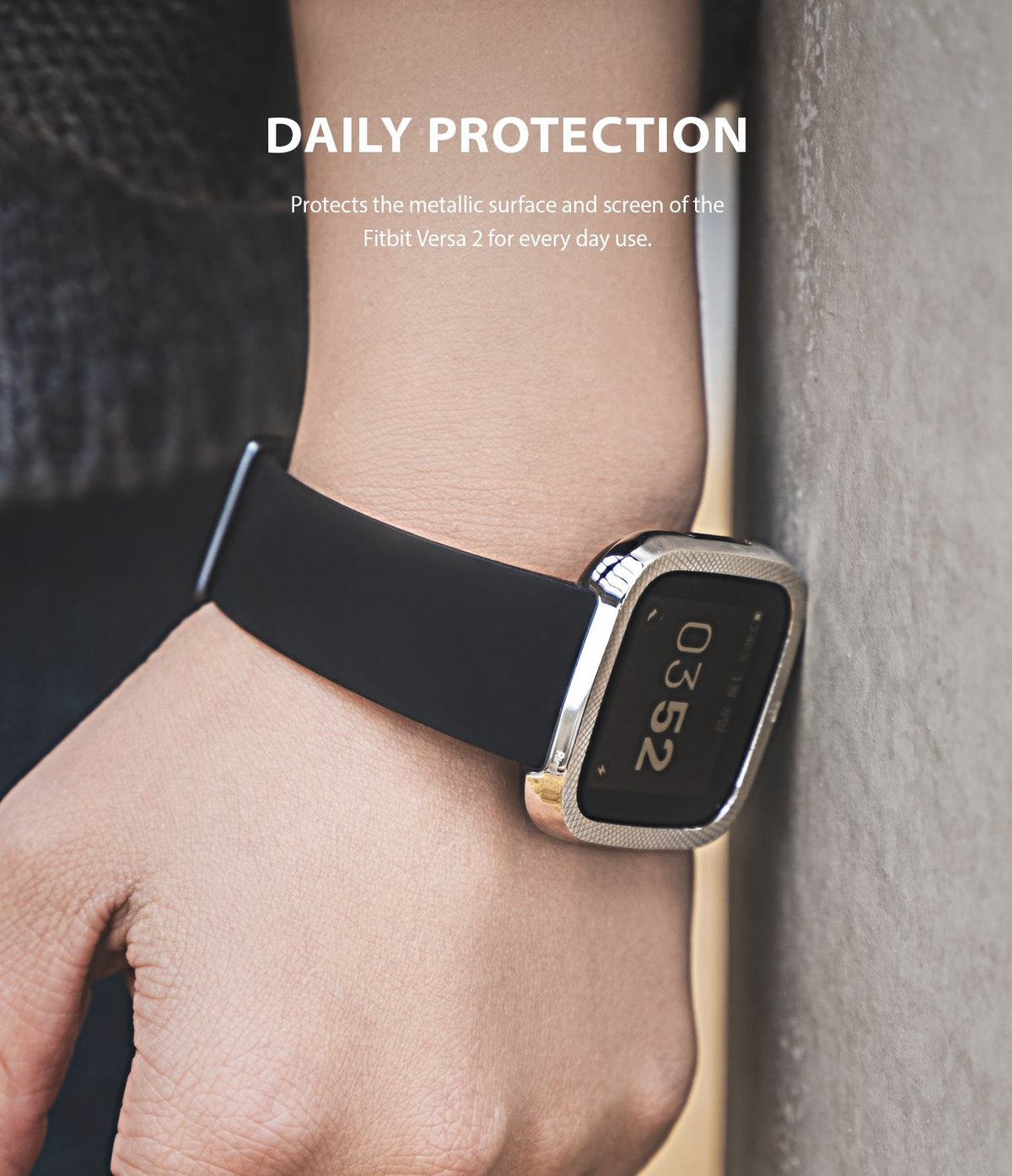 Fitbit Versa 2 | Bezel Styling 42 - A silver metallic bezel protector on a Fitbit Versa 2 worn against a concrete wall.