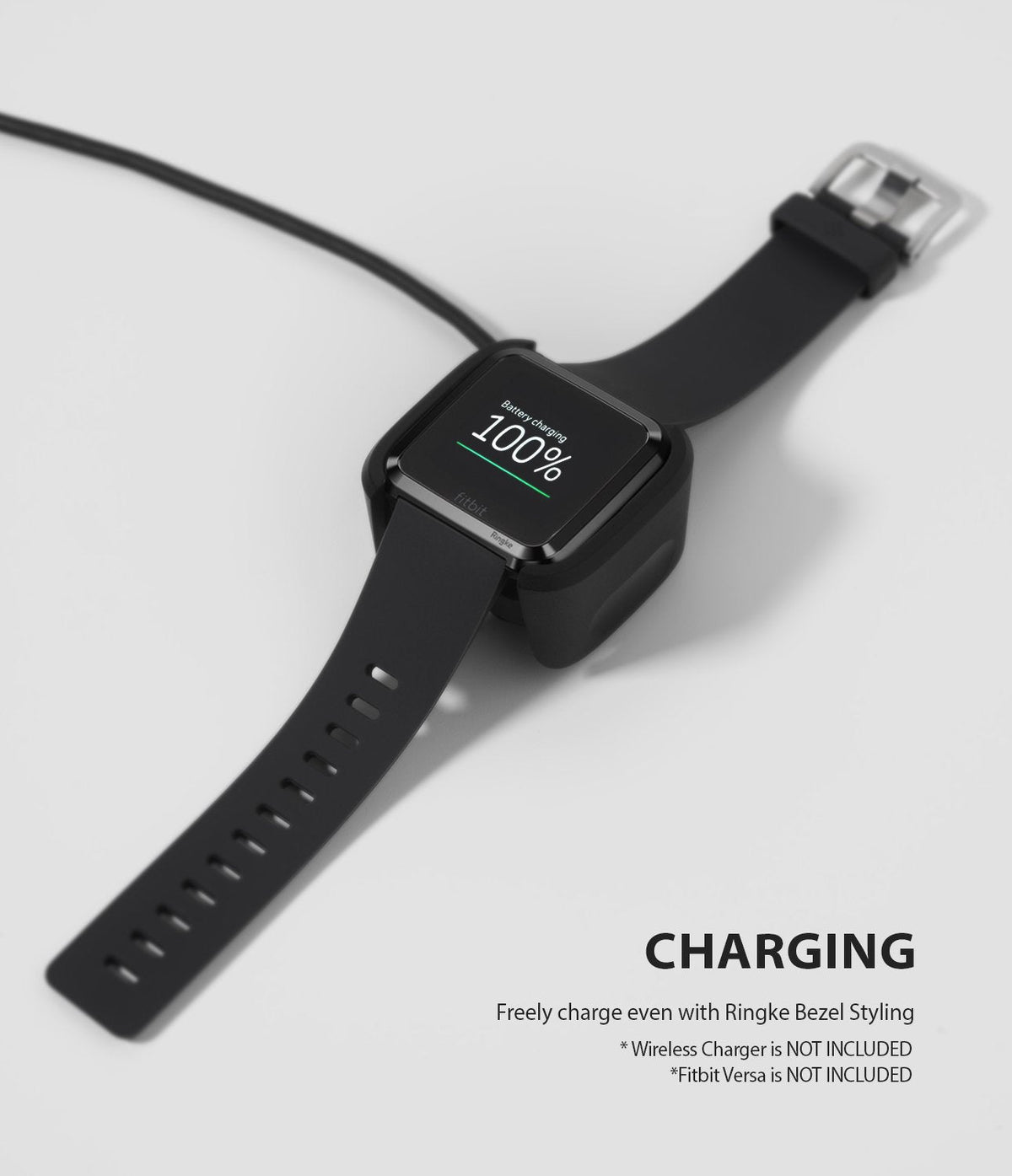 Fitbit Versa | Bezel Styling 03 - Black Fitbit Versa with a bezel accessory charging on a wireless dock at 100 percent.