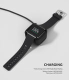 Fitbit Versa | Bezel Styling 03 - Black Fitbit Versa with a bezel accessory charging on a wireless dock at 100 percent.