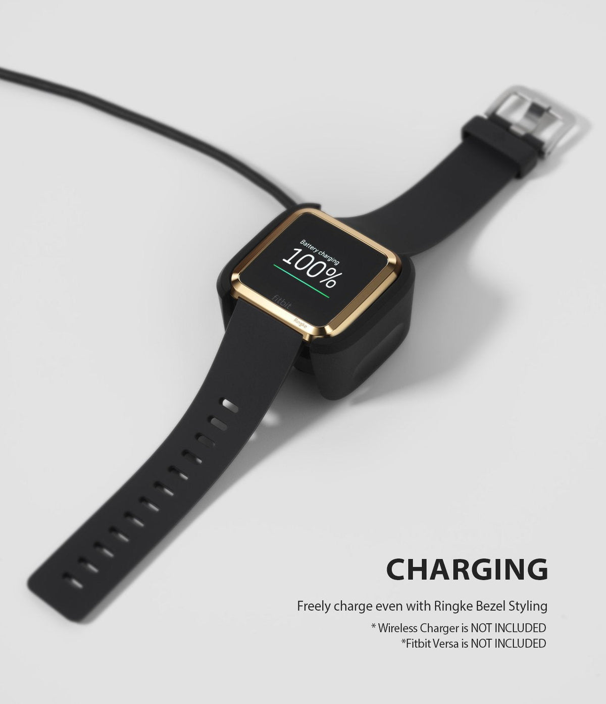 Fitbit Versa | Bezel Styling 05 - A Fitbit Versa with a gold bezel styling accessory charging on a black dock.