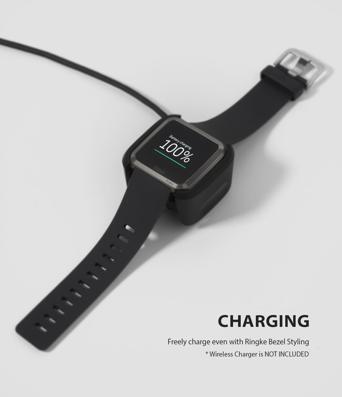 Fitbit Versa | Bezel Styling 06 - A Fitbit Versa with a bezel accessory charging on a dock, showing 100% battery.