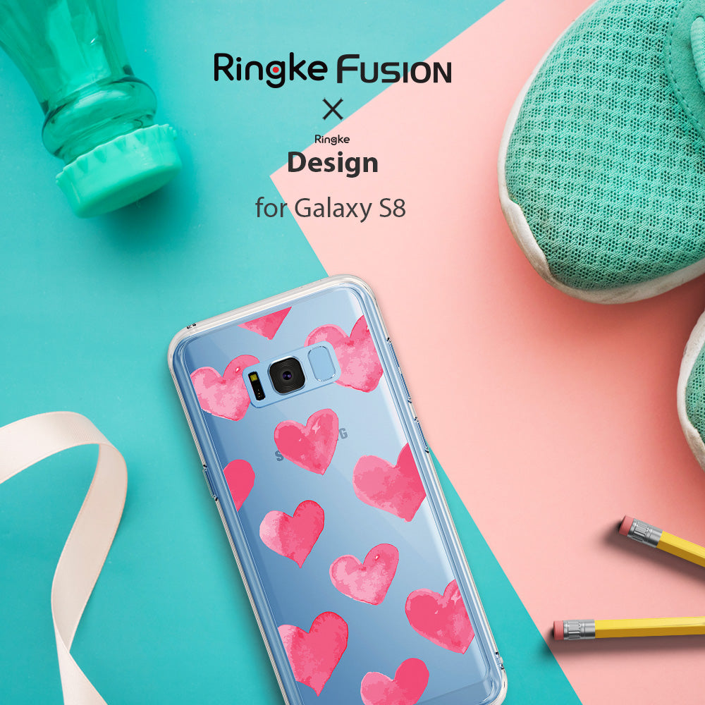 Galaxy S8 Case | Fusion Deco - Clear phone case with pink watercolor hearts on a split teal and pink background with accessories.