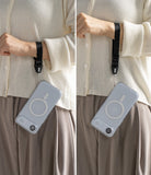 Dual Hand Slim Strap - A person wearing a black wrist strap attached to a clear smartphone case with a MagSafe ring.