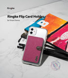 Card Holder | Flip [2 Pack] - A magenta fabric flip card holder attached to a clear phone case resting on a stack of books.