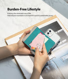 Card Holder | Flip [2 Pack] - Hands holding a teal adhesive card holder attached to a clear phone case with a card being inserted.