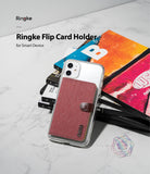 Card Holder | Flip [2 Pack] - A red fabric flip card holder attached to the back of a clear smartphone case resting on books.
