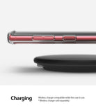 Galaxy Note 10 Case | Fusion - A red smartphone in a clear case hovering above a black wireless charging pad.