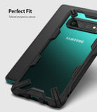 Galaxy S10 Case | Fusion-X - Black rugged protective case on a teal Samsung Galaxy S10 with precise camera and port cutouts.