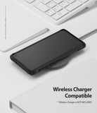 Galaxy S10 Case | Fusion-X - Black phone case on a wireless charging pad next to a white keyboard and notebook.