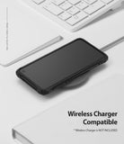 Galaxy S10e Case | Fusion-X - Black phone case on a wireless charging pad next to a white keyboard and notebook.