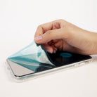 Galaxy S8 Plus Case | Mirror - Hand peeling a protective blue film off the reflective back of a clear smartphone case.