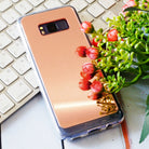 Galaxy S8 Plus Case | Mirror - Rose gold mirrored phone case on a white keyboard with red flowers reflecting on the surface.