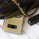 Galaxy S8 Plus Case | Mirror - Gold mirror phone case reflecting a gold chain strap next to a black handbag and lipstick.