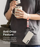 Hand Strap | Basic - A person wearing a pink fabric wrist strap attached to a smartphone, holding a mug with their other hand.