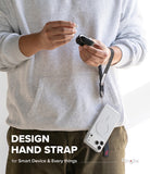 Hand Strap | Basic - Person wearing a grey hoodie holding a black earbud case attached to a phone via a black fabric hand strap.