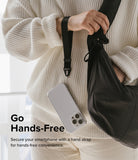 Hand Strap | Basic - Person wearing a white sweater holding a black hand strap attached to a clear smartphone case.