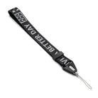 Hand Strap | Lettering - Black fabric wrist strap with white "BETTER DAY" text, black plastic buckle, and thin gray loop.