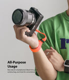 Hand Strap | Black / Neon Orange - A person wearing a neon orange wrist strap attached to a black mirrorless camera.