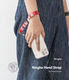 Hand Strap | Lettering - A person wearing a red Ringke branded fabric wrist strap attached to a smartphone in a clear case.