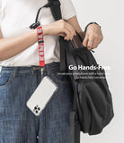 Hand Strap | Lettering - Person wearing a red Ringke branded wrist strap attached to a clear smartphone case hanging by a backpack.