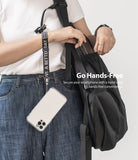 Hand Strap | Lettering - Person wearing a black strap with white lettering attached to a smartphone hanging from their wrist.