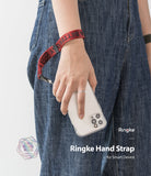 Hand Strap | Lettering - A person wearing a red fabric wrist strap with black lettering attached to a clear phone case.