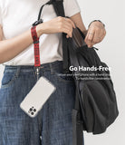 Hand Strap | Lettering - A person wearing a red branded wrist strap attached to a clear smartphone case hanging by their side.