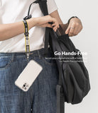 Hand Strap | Lettering - A person wearing a yellow and black branded wrist strap attached to a clear smartphone case.