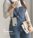 Shoulder Strap | Black / Neon Orange - Person wearing a phone on a black shoulder strap while holding a mug and books.