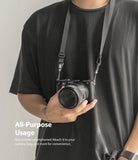 Shoulder Strap | Black / Neon Orange - Person wearing a black camera strap attached to a Sony mirrorless camera.