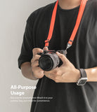 Shoulder Strap | Black / Neon Orange - Person wearing a neon orange shoulder strap attached to a black Sony camera.