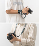 Shoulder Strap | Lettering - Person wearing a camera strap with Ringke branding wrapped around their wrist and worn around the neck.