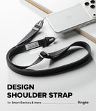 Design Shoulder Strap - A black woven shoulder strap with silver metal hardware, shown draped over a clear smartphone case on a white surface. Text at the bottom reads 'DESIGN SHOULDER STRAP for Smart Devices & more Ringke'.