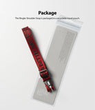 Shoulder Strap | Lettering - Red shoulder strap with black lettering resting on its clear, branded recyclable packaging pouch.