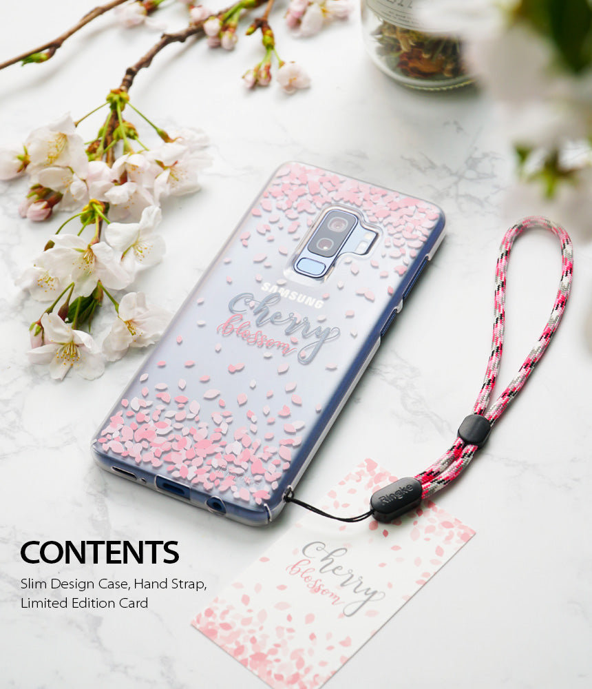 Galaxy S9 Case | Slim (Cherry Blossom) - Clear phone case with pink petals, hand strap, and card on marble surface.
