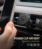 Power Clip Air Vent Car Mount [2 in 1] - Power Clip Air Vent Car Mount - A hand holding a smartphone near a speedometer-style magnetic car mount attached to a vent.