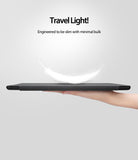 Smart Cover Clear Slim Stand | iPad - Smart Cover Clear Slim Stand - A hand holds a slim, dark gray iPad case with a white feather floating above it against a light background.