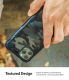 iPhone 11 Pro Max Case | Fusion-X Design - Hand holding a phone with a black, semi-transparent camo pattern case.