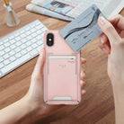 iPhone X Case | Slim + Slot Card Holder - Hands holding a peach pink iPhone case with a card slot, inserting a credit card.