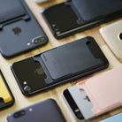 Card Holder | Slot [Solid - 2 Cards] [2 Pack] - Black - Black Ringke card holders attached to the backs of various smartphones.