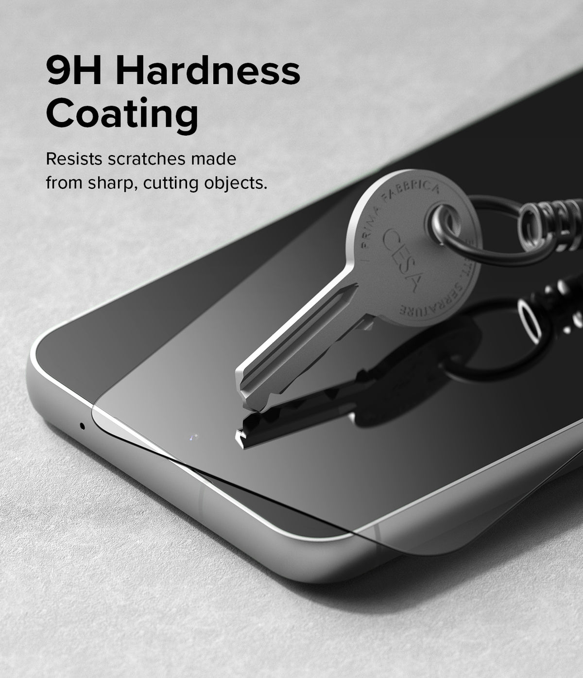 Galaxy S23 FE Screen Protector | Full Cover Glass - Galaxy S23 FE Screen Protector - A metal key resting on a smartphone screen to demonstrate 9H hardness scratch resistance.