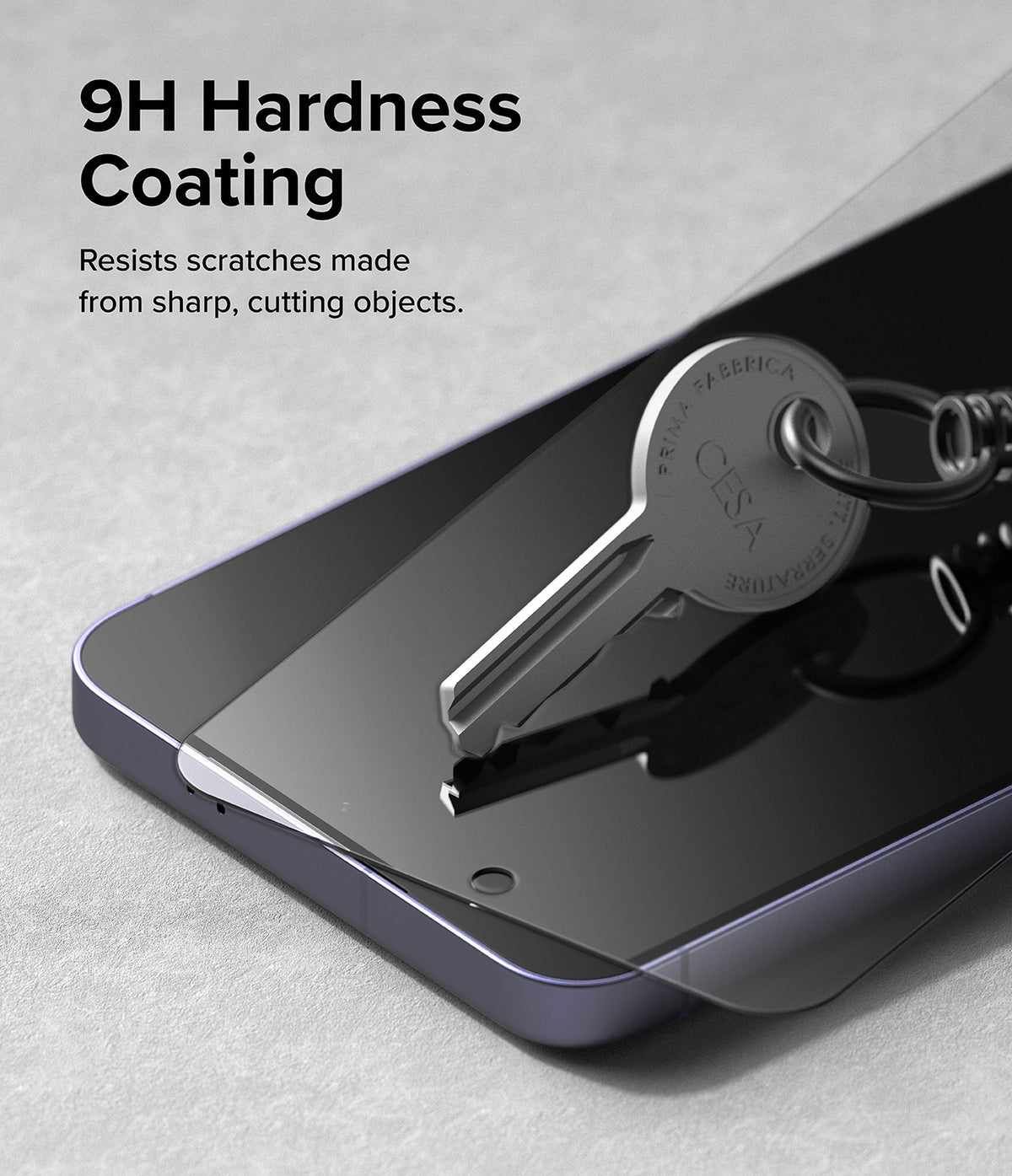 Galaxy S24 Screen Protector | Easy Slide Tempered Glass - Galaxy S24 Screen Protector - A metal key resting on a tempered glass screen protector atop a smartphone.