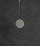 Galaxy S25 Ultra Case | Alles - A circular magnetic wireless charger hanging against a dark, textured gray background.