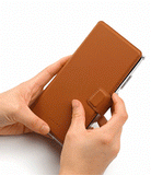 Galaxy S25 Ultra Cover | Folio Grip Wallet Magnetic - Hands closing a tan leather folio case over a smartphone.