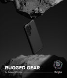 Galaxy S25 Ultra Case | Rugged Gear - Black phone case suspended between two jagged rocks against a dark background.