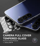 Galaxy S26 FE Camera Protector | Camera Full Cover Tempered Glass (2P) - Ringke camera full cover tempered glass protector shown applied to the rear camera area of a blue Samsung Galaxy S26 FE smartphone, with additional protective film sheets visible on a dark background and product text overlay.