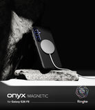 Galaxy S26 FE Case | Onyx Magnetic - A black phone case with a large circular magnetic ring, shown attached to a smartphone and resting on a rock against a dark background. Text at the bottom reads 'onyx MAGNETIC for Galaxy S26 FE' with Ringke branding.