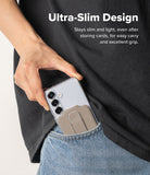 Card Holder | Slide Grip Wallet Magnetic Edge - A hand sliding a phone with a beige magnetic card holder into a jeans pocket.